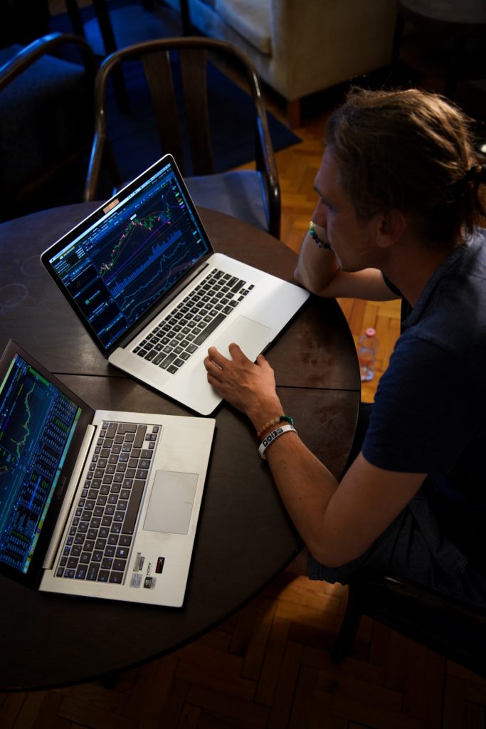 Person working on two laptops