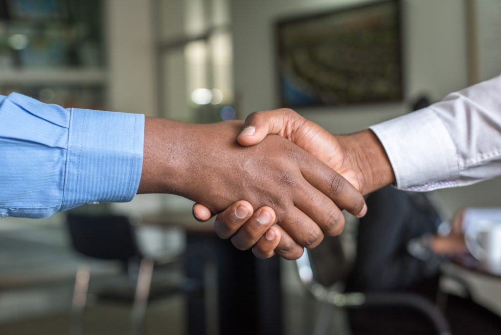 People shake hands, representing work across states.