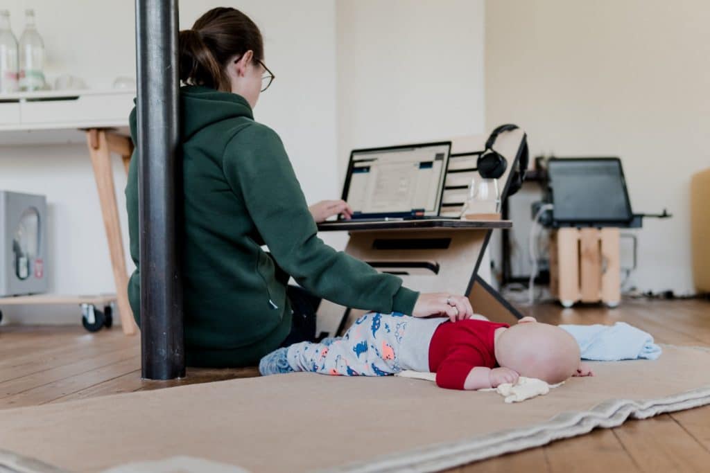 Person working on laptop with baby
