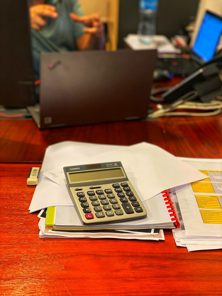 Calculator sitting atop paperwork on a desk