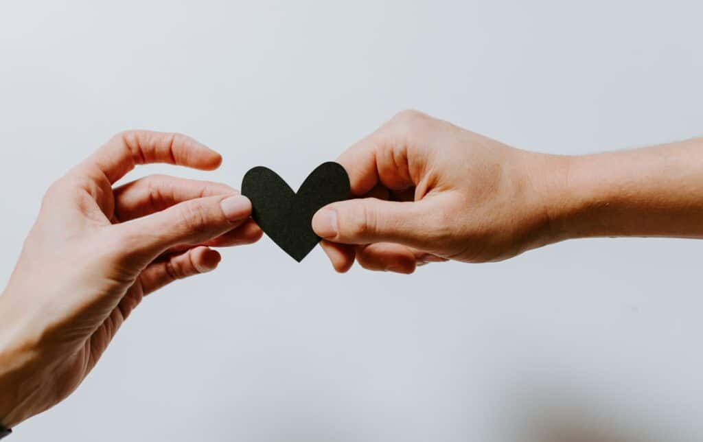 hands on a black paper heart