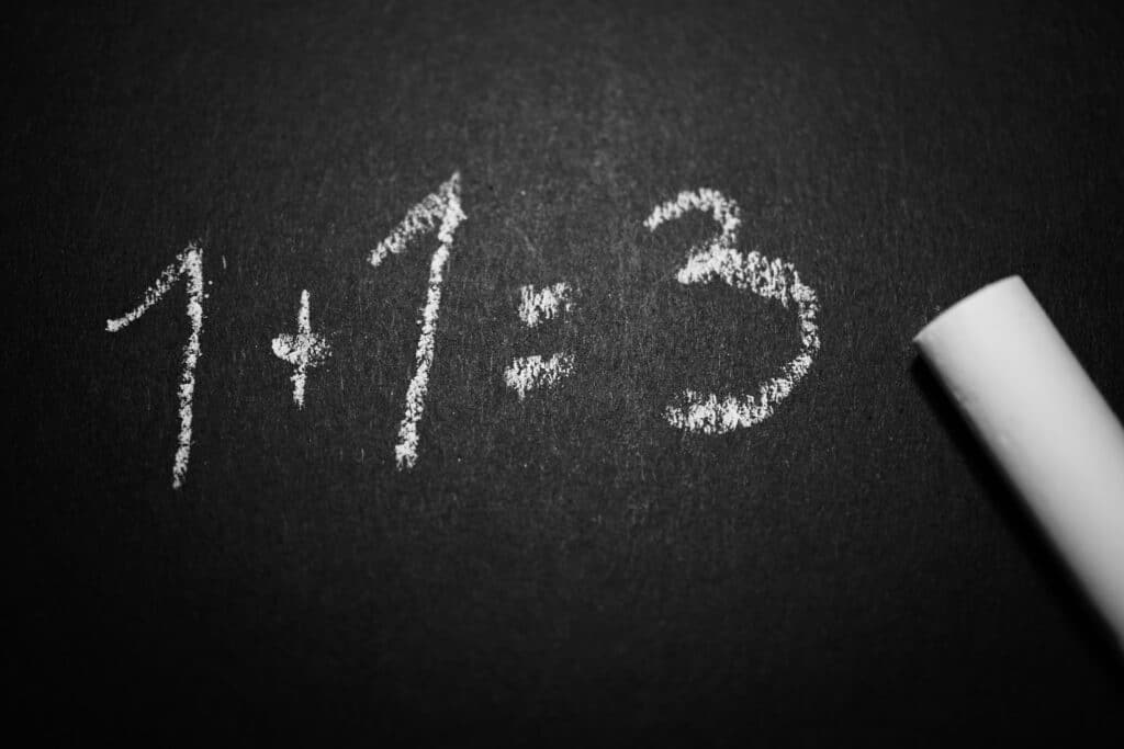 1 + 1 = 3 written on a chalkboard