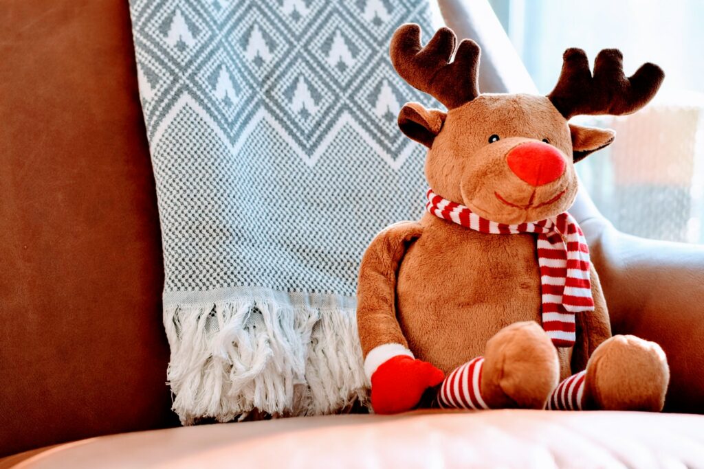 Stuffed reindeer sitting on a chair.