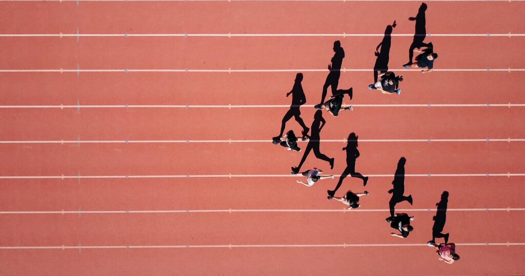 the shadows of people running around a track.