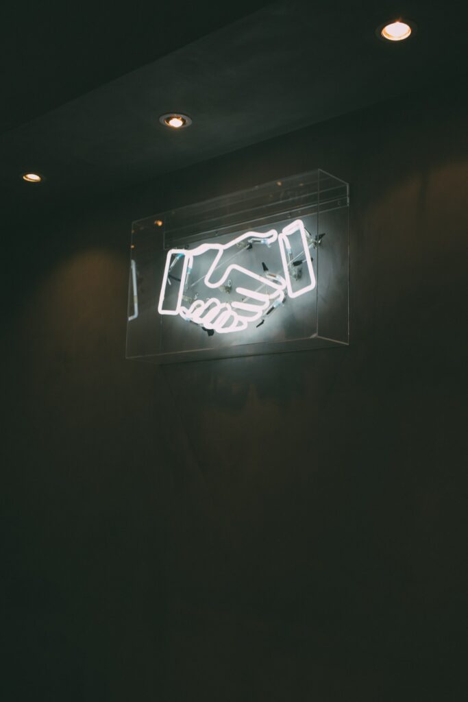 Neon sign of a handshake.