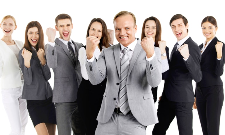 A group of people in business dress celebrate insurance regulations