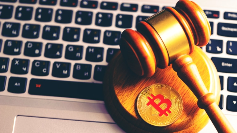 Laptop keyboard with gavel and a coin with the bitcoin logo on it. Vermont Department of Financial Regulation settled a multi-state suit for selling unregistered cryptocurrency interest-bearing accounts to Vermont investors.