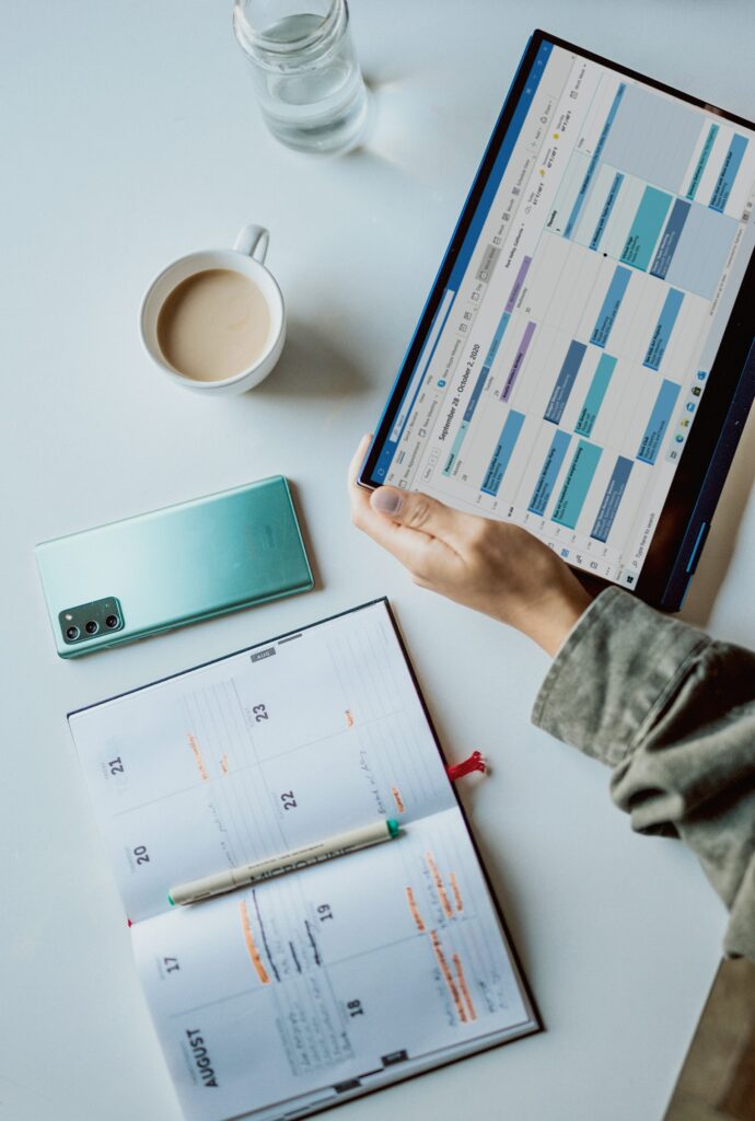 Woman's hand holding a tablet viewing calendar dates.