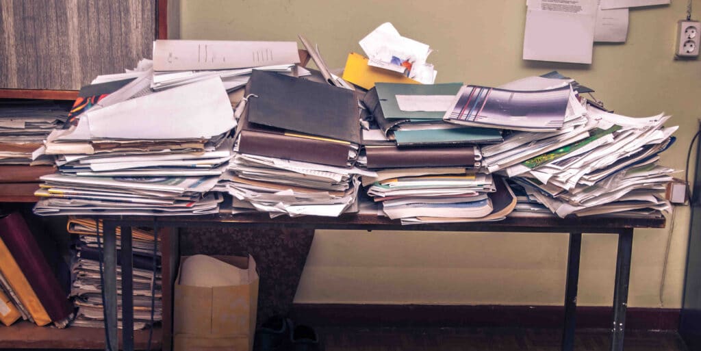 A table of unorganized files, papers, and folders representing unstructured data.