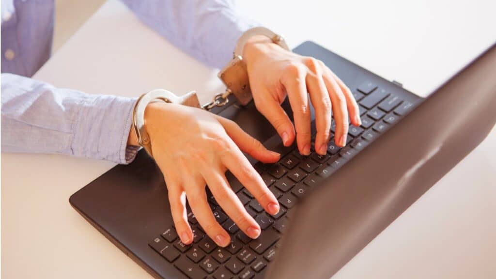 Person in handcuffs using a laptop computer