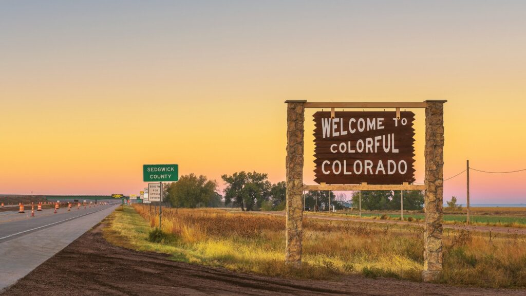 Picture of roadside sign "Welcome to Colorful Colorado" at sunset