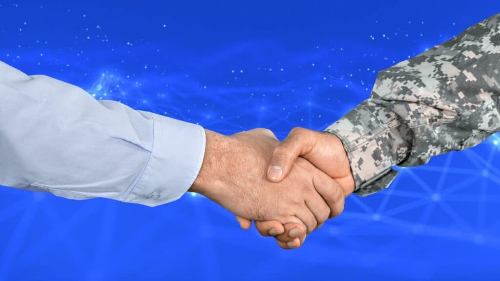 close-up of a handshake between a businessperson and a military veteran