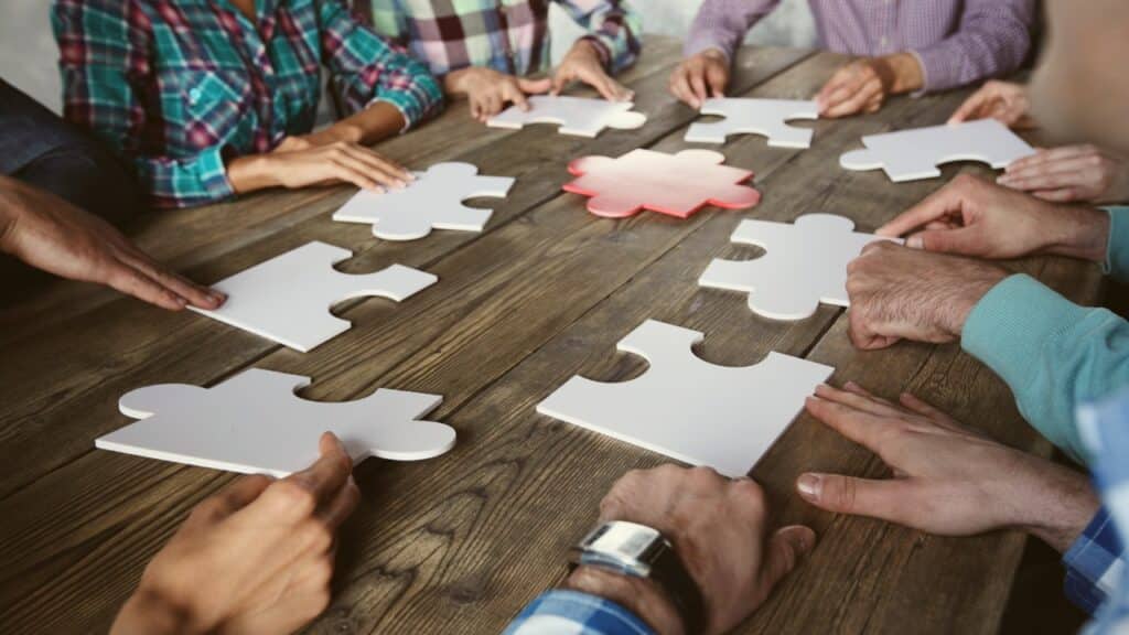 Close-up of hands putting a puzzle together