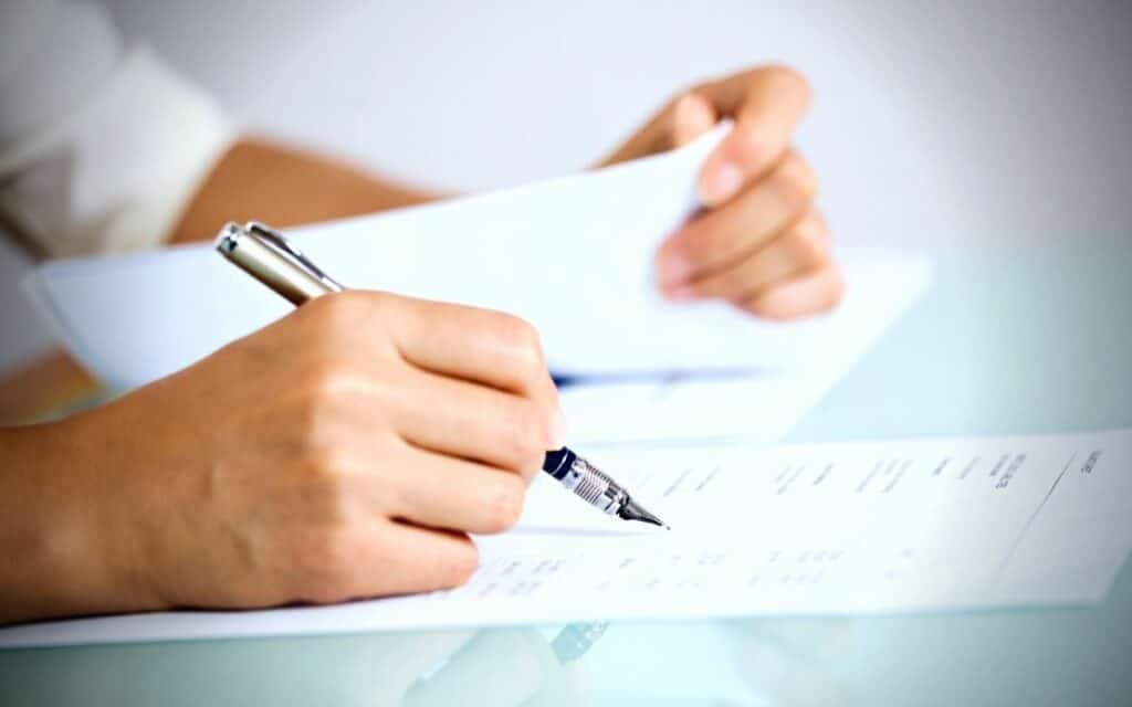 Person taking notes on a sheet of paper