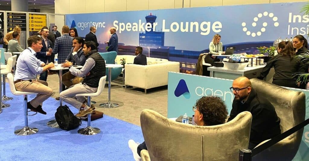 photo of people in the Insurtech Insights Speaker Lounge. Some are seated in chairs and at tables.